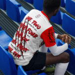 One, Two, Freddie's Coming For You Man Wearing A Football Jersey Sitting On A Bleacher Seat.